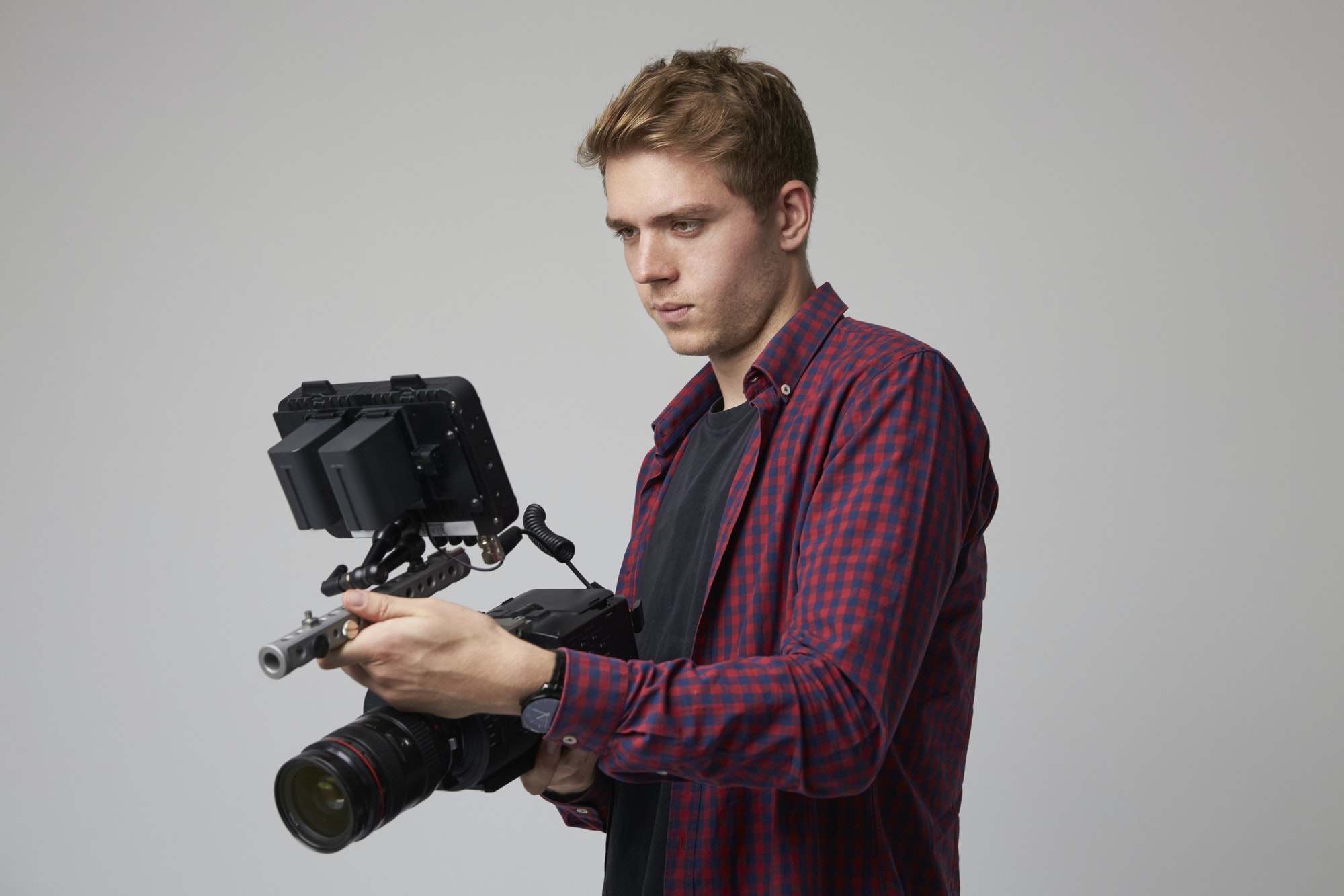 Studio Portrait Of Male Videographer With Film Camera