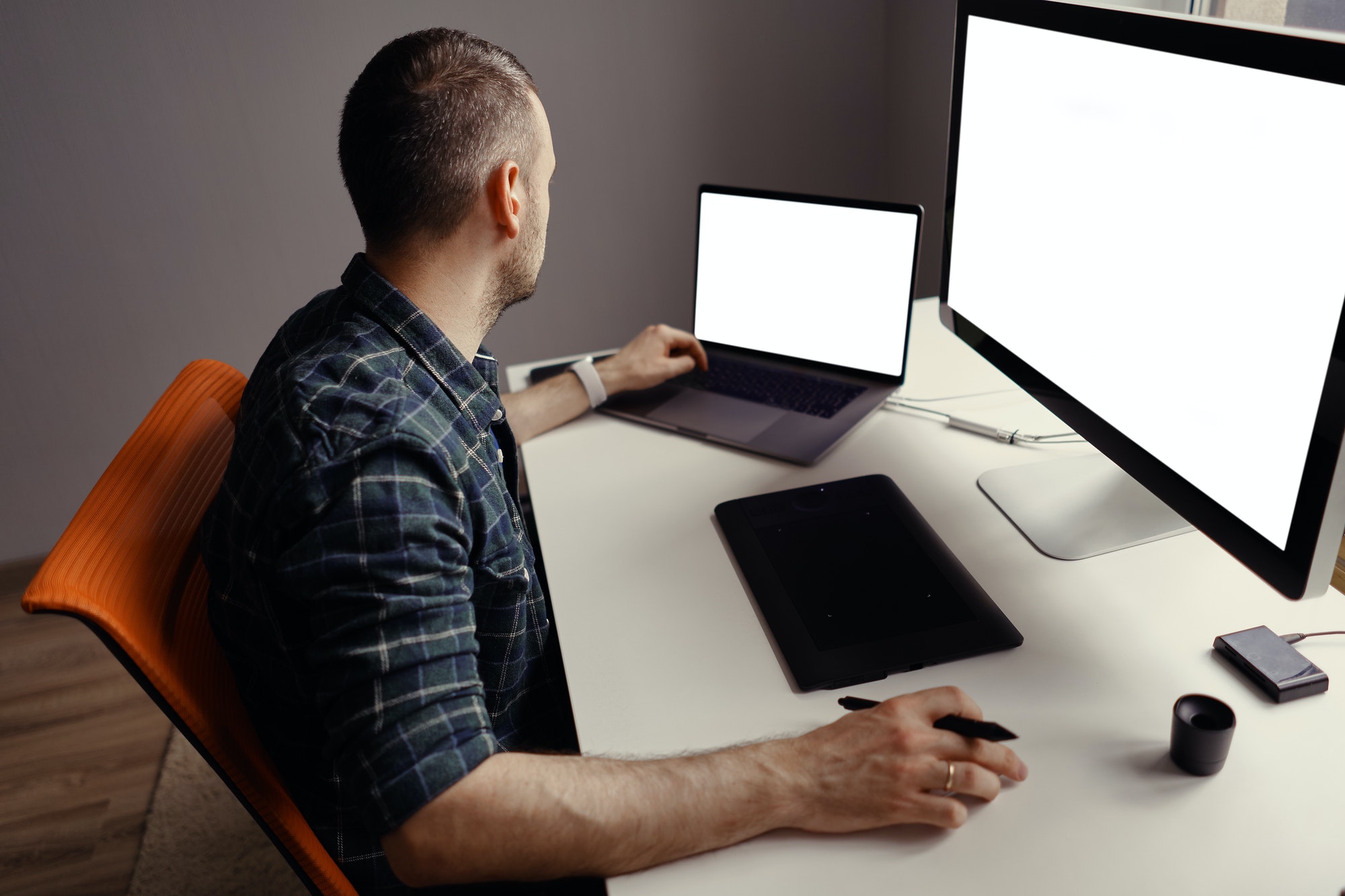 Young man working with interactive pen display and computer